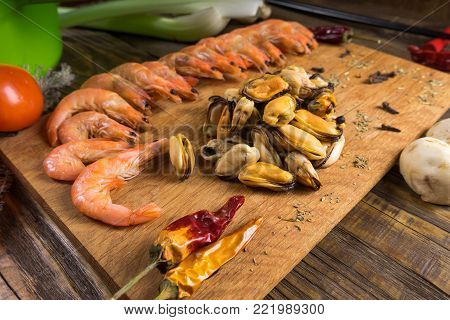 Sum tomato with shrimps and mussels on the plate on the serving Board at a beautiful stone table.