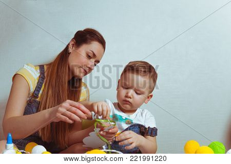 kid with mother color eggs for easter together