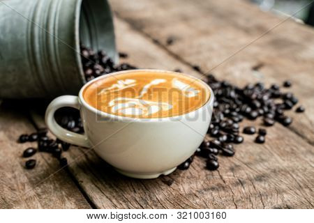 Latte Art Coffee In White Cup With Roast Bean