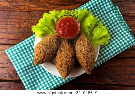 Fried Kibbeh With Tomato Sauce On A Plate, Over Rustic Wooden Table
