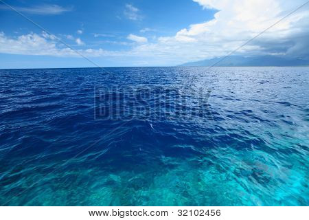 Blå klara havet med vågor och himlen med moln