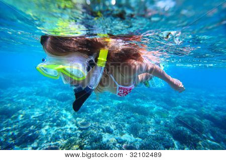 Jeune femme, plongée en apnée sur la barrière de corail en mer tropicale avec de l'eau transparente