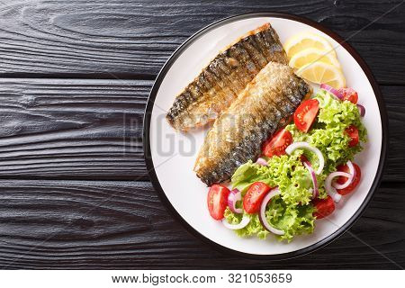 Healthy Food Grilled Mackerel Fillet With Lemon And Fresh Vegetable Salad Close-up On A Plate. Horiz