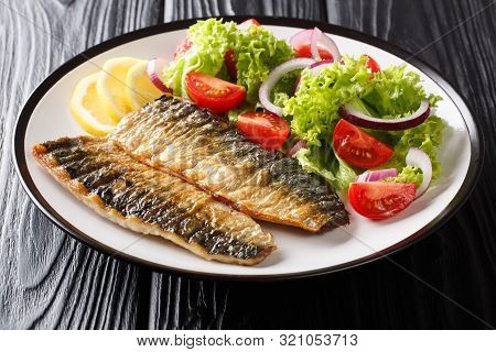 Healthy Food Grilled Mackerel Fillet With Lemon And Fresh Vegetable Salad Close-up On A Plate. Horiz