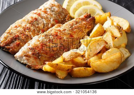 Serving Of Grilled Mackerel Fillet With Potato Wedges And Lemon Closeup On A Plate. Horizontal