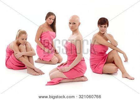 Young women wrapped into pink textile sitting on floor. 
This is a free image, part of a charity project. Models and the staff worked for free to support breast cancer awereness campaigns worldwide.
