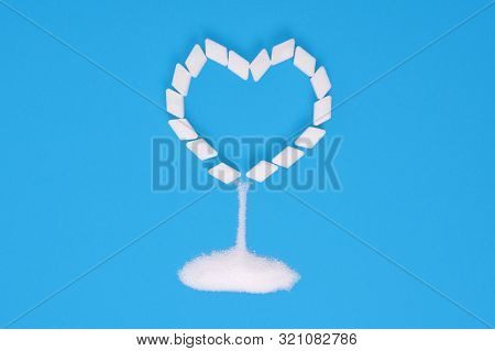 Sugar Cubes On A Blue Background In The Shape Of A Heart With Sprinkling Sugar. Diabetes, Heart Dise