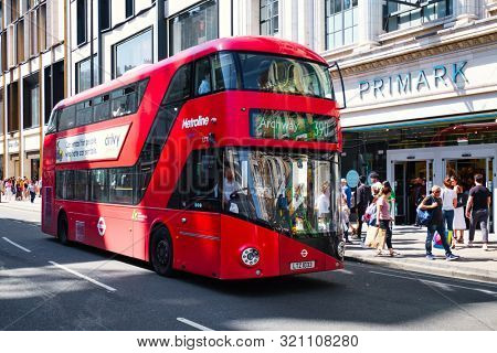 LONDON,UK - JULY 29,2019 : Typical red double decker bus next to the Primark store at Oxford Steet in London
