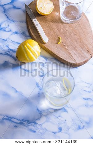 Gintonic Cocktail In A Glass With Ice And Lemon, With The Ingredients Aside.