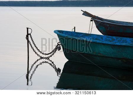 Old Fishing Boats With Chain On Lake At Sunset In Summer
