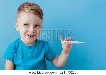 Ill Young Child With A Thermomether, Measuring The Height Of His Fever And Looking Into The Camera