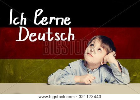 Thinking Child Boy Student Against The Germany Flag Background. Deutsch Concept With Inscription Lea