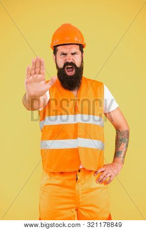 Stop, Mining Area Under Construction. Mining Engineer Showing Caution Sign On Yellow Background. Con