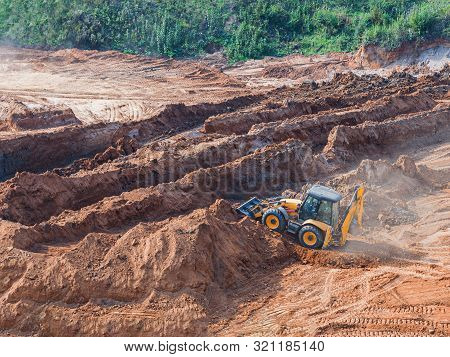 Wheel Loader Excavator Machine Working In Construction Site. Wheel Loader At Sandpit During Earthmov