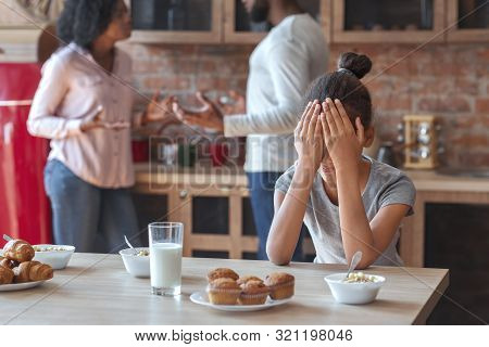 Family Problems Concept. Black Girl Covering Her Eyes With Hands, Parents Figting, Kitchen Interior