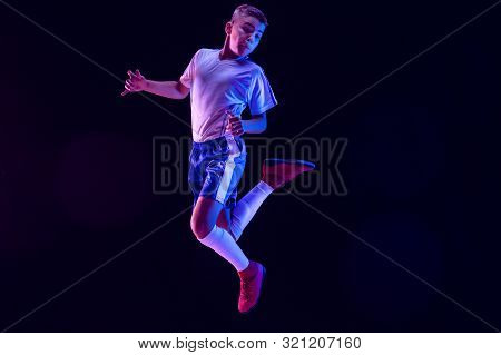 Young Boy As A Soccer Or Football Player In Sportwear Making A Feint Or A Kick With The Ball For A G