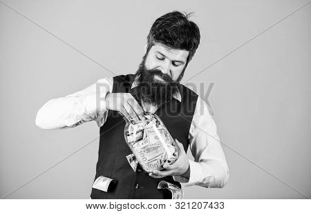 Hiding Money For Future Use. Bearded Man Investing Money From Glass Jar For Future Profits. Business