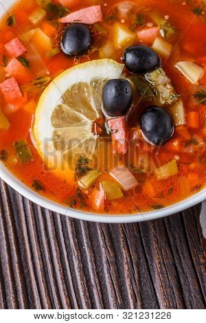 Traditional Russian Meat Soup Solyanka In Bowl On Rustic Wooden Table