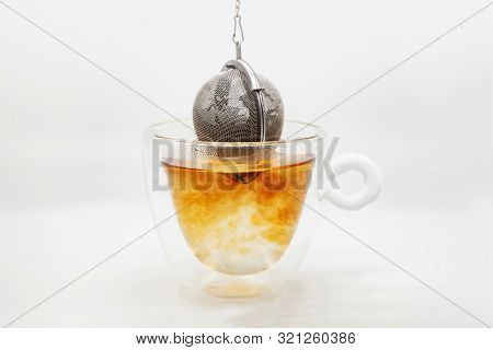 Tea Strainer With Tea Leaves Dropped In Glass Cup Of Boiling Water