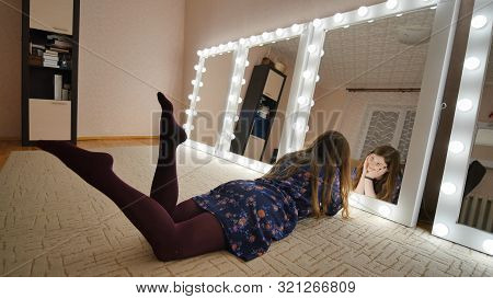 The Girl Is Lying In Front Of The Mirrors And Flirting With Herself. Manufacture Of Make-up Mirrors.