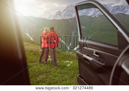Happy Couple Hugs On Beautiful Nature And Mountains Out Of Car