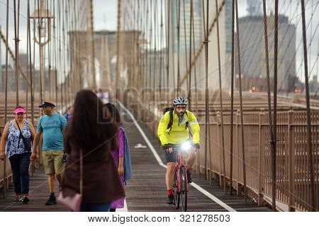 New York, Usa - 12 July 2019: Pedestrians Walk Over The Brooklyn Bridge At Sunset. Traffic Of People
