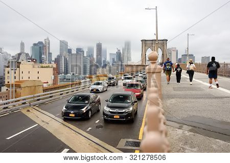 New York, Usa - 11 July 2019: Traffic Of People And Cars On Brooklyn Bridge In Foggy Day. Famous Bri