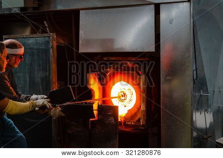 Kalamazoo, Mi/usa - December 4th 2015: Sticking Glass Into The Crucible Furnace To Heat It Back Up A