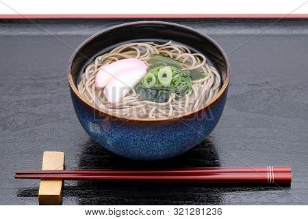 Japanese Kake Soba Noodles In A Ceramic Bowl With Chopsticks On Tray
