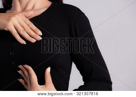 Woman Hand Checking Lumps On Her Breast For Signs Of Breast Cancer On Gray Background. Healthcare Co