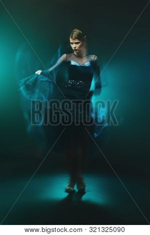 Beautiful girl performs Latino dance with expression. Professional dancer in motion. Beauty, fashion.