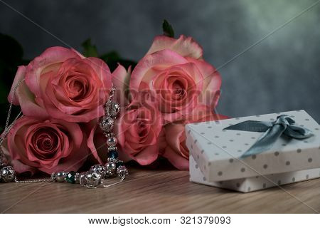 Dolce Vita Roses With Dotted White Present Box On Wood Background