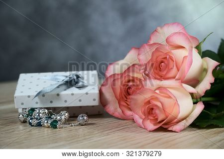 Dolce Vita Roses With Dotted White Present Box On Wood Background