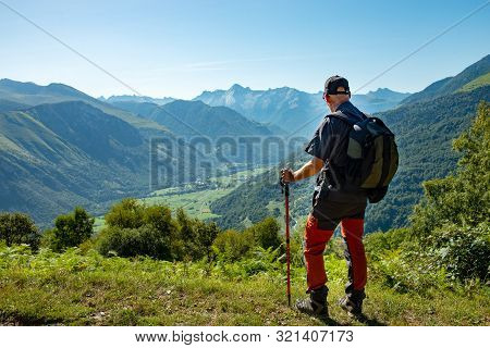 A Man With Backpack Hiking In Pyrenees Mountains