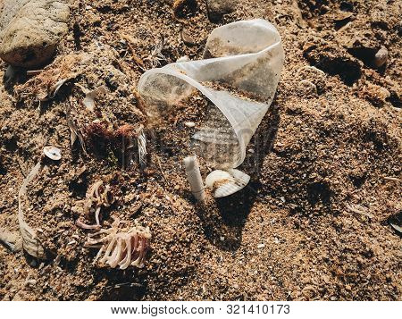 Plastic Pollution On The Beach. Single Use Plastic Cup In Sand, Marine Trash On The Beach. Stop Plas