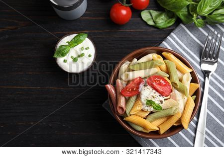 Delicious Vegetable Pasta With Sour Cream Dressing On Black Wooden Table, Flat Lay