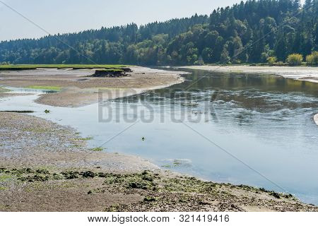 The Nisqually River Flows Past Mud Flats In The Nisqually Wetlands Near Olympia, Washington.