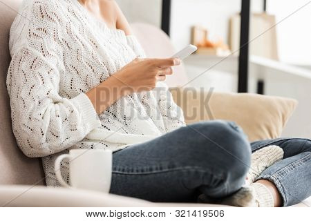 Cropped View Of Woman In White Sweater And Jeans Using Smartphone