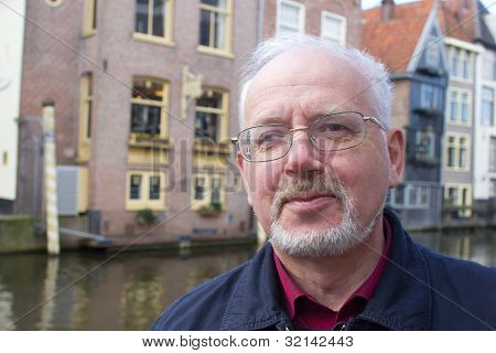 Closeup Portrait Of Smiling Old Man With A Grey Beard