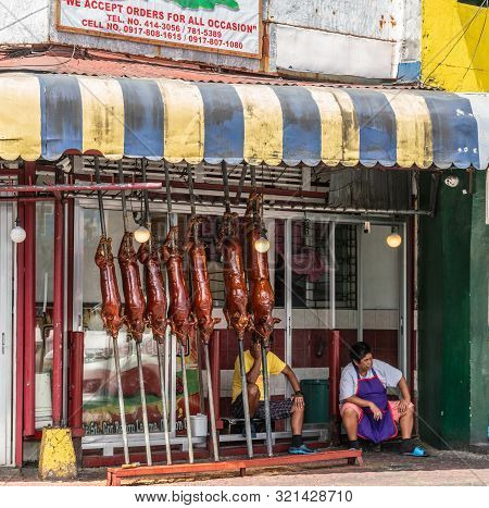 Manila, Philippines - March 5, 2019: Calavite Street In Salvacion Part Of Town. Seven Whole Piglets 