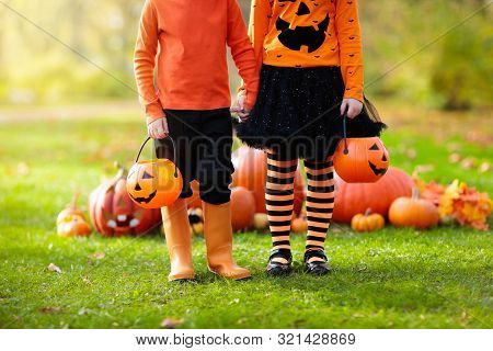 Kids With Pumpkins In Halloween Costumes