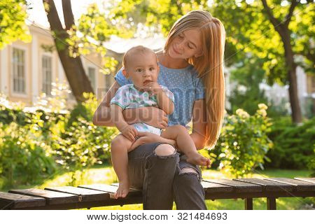Teen Nanny With Cute Baby Outdoors On Sunny Day