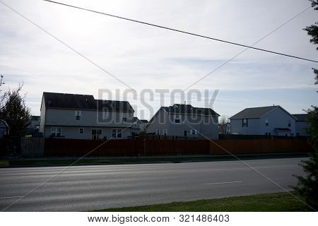 Two Story Single Family Tract Homes, Behind Wooden Stockade Fences, In Joliet, Illinois, During Dece