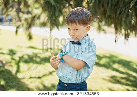Little Boy Talking On Smart Watch With Mother.