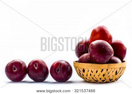Raw Organic Red Ripe Plums In A Brown-colored Basket Isolated On White For Easy To Use For Any Purpo