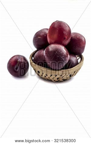 Raw Organic Red Ripe Plums In A Brown-colored Basket Isolated On White For Easy To Use For Any Purpo