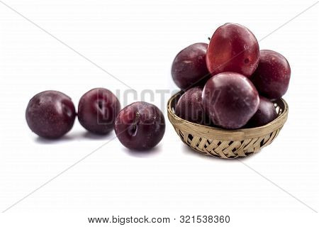 Raw Organic Red Ripe Plums In A Brown-colored Basket Isolated On White For Easy To Use For Any Purpo