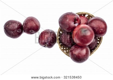 Raw Organic Red Ripe Plums In A Brown-colored Basket Isolated On White For Easy To Use For Any Purpo