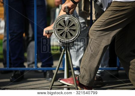 Shallow Depth Of Field Image With A Man Handling A Vintage Hand Crank Air Raid Siren