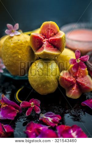 Raw Organic Guava Or Amrut Or Amarood In Hindi Language On Black Shinny Surface In A Blue-colored Pl